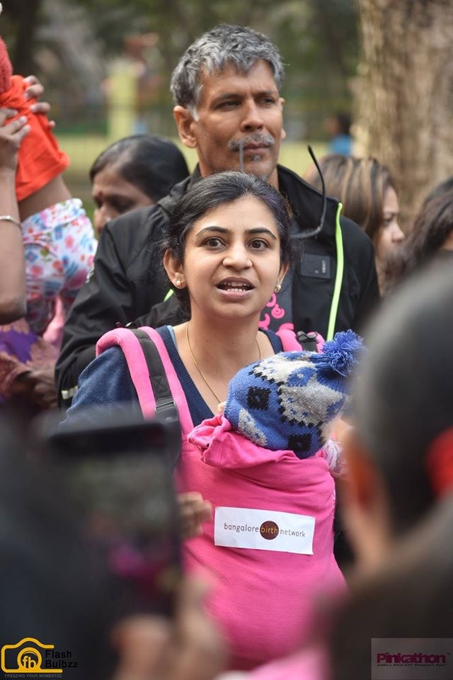 A mother carrying her baby at a community health event