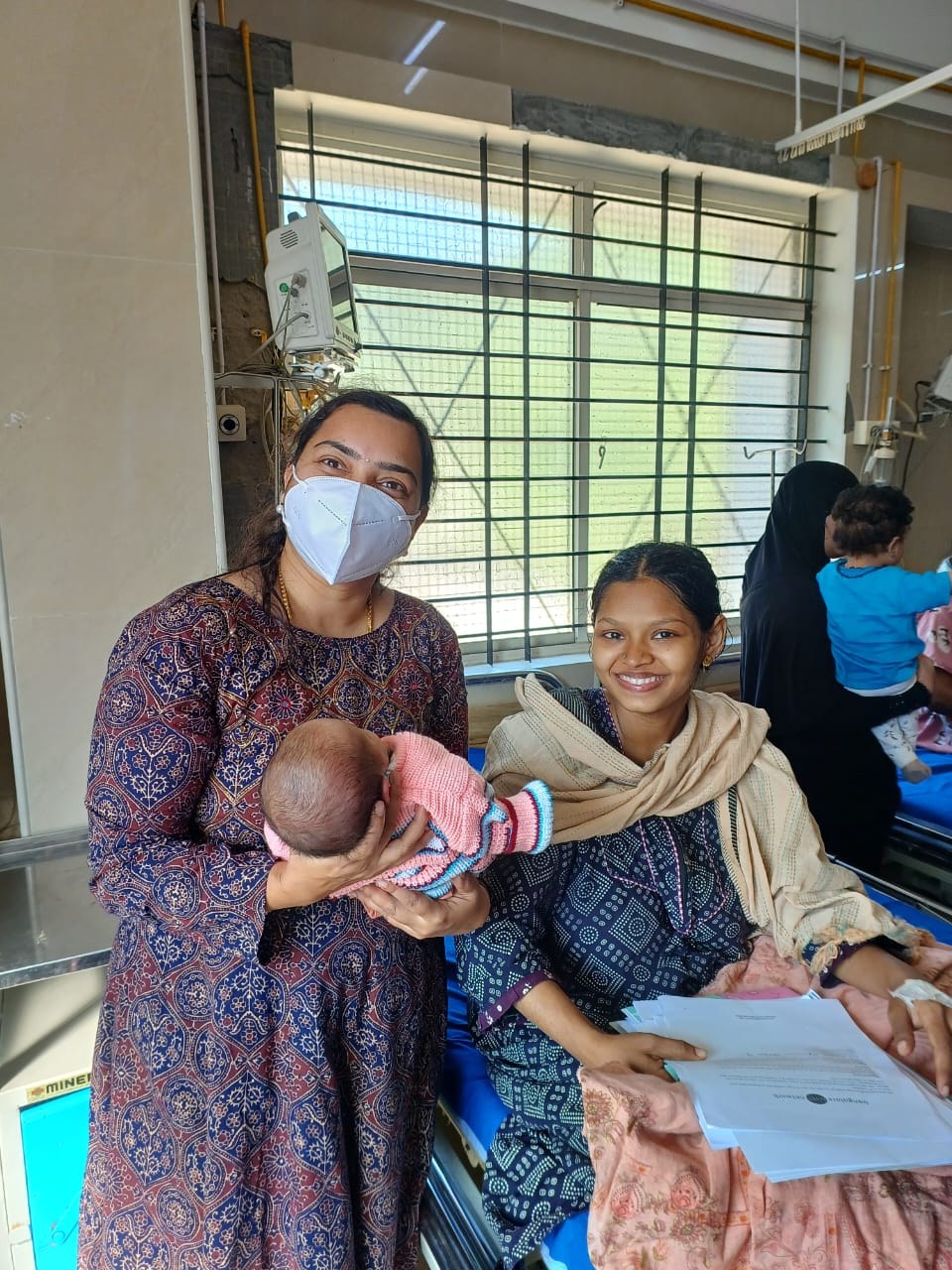 A health worker with a mother and her newborn at a Bangalore clinic