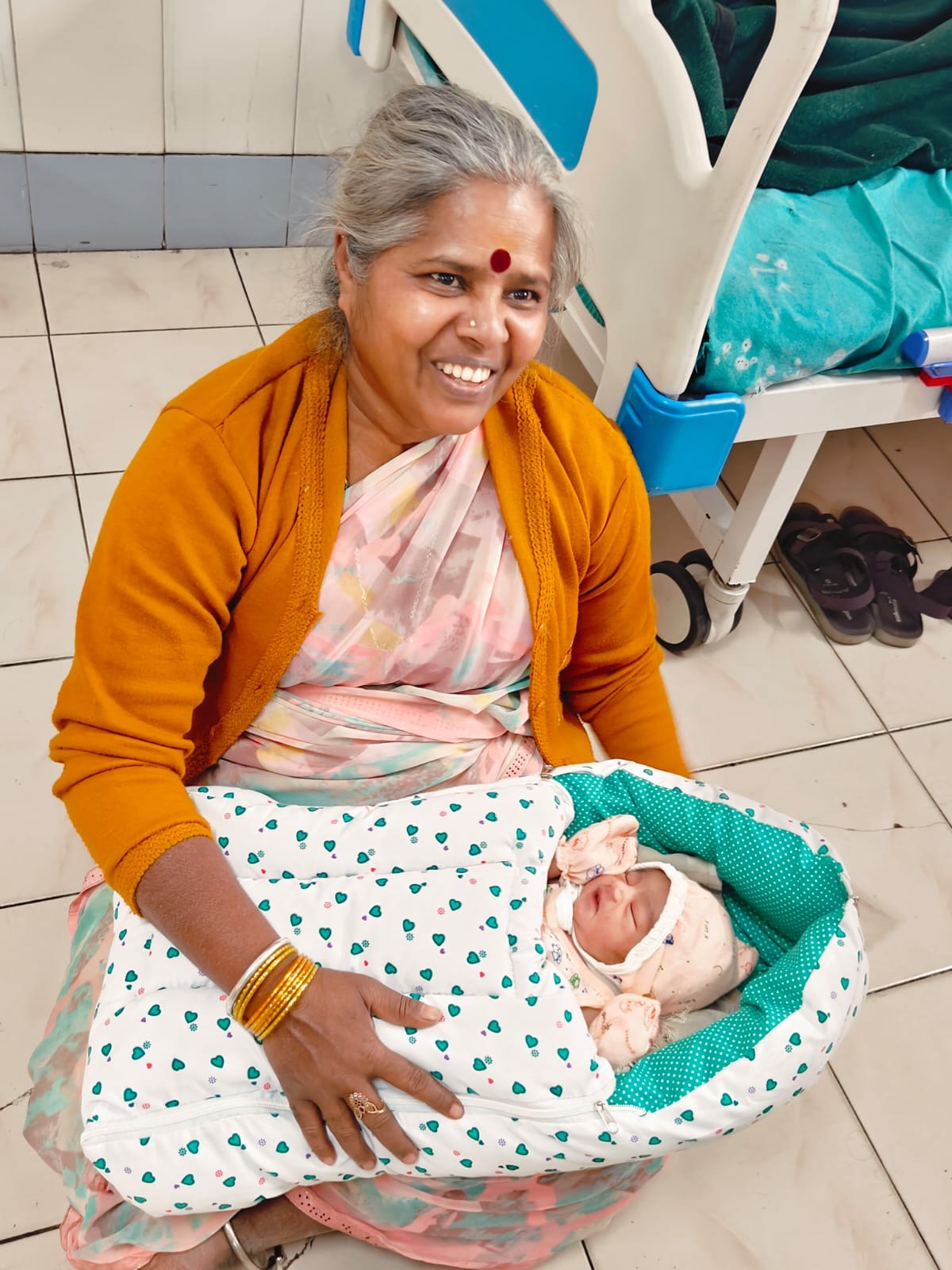 A health worker holding a swaddled newborn