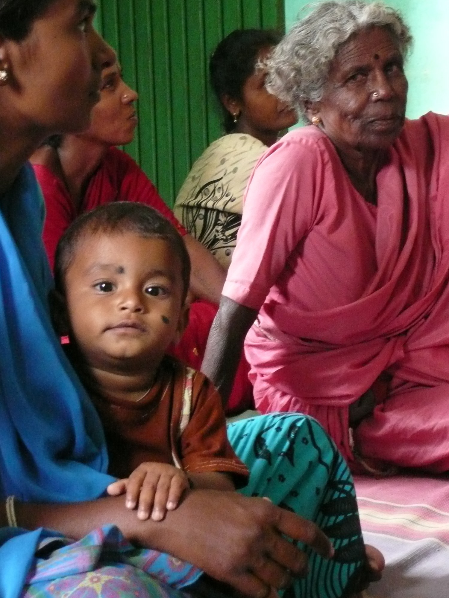 A grandmother, mother and child together at home